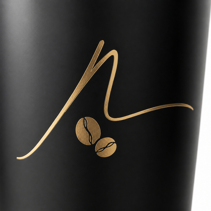 Macro close-up of premium gold foil stamping coffee bean brand logo on matte black disposable paper coffee cup