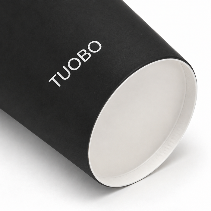 Close-up view showing the bottom construction and white interior of a black printed disposable paper cup with a white logo.