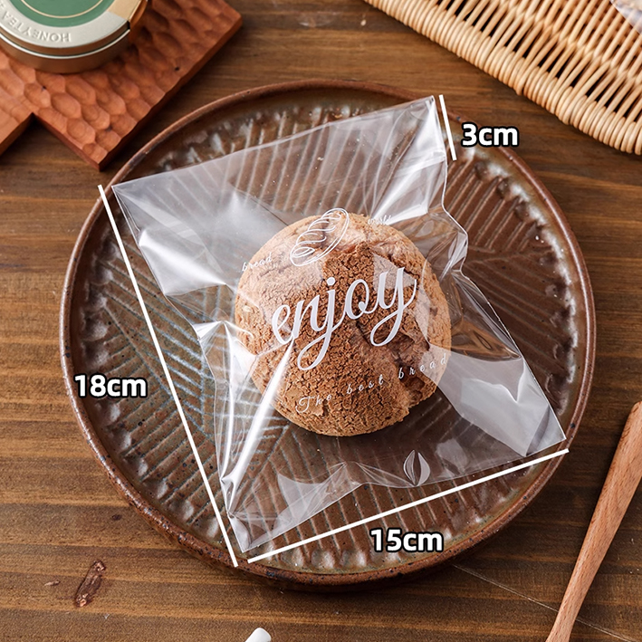 18×15cm transparent printed bagel bag holding a crispy bun, ideal for packing individual baked goods or single servings from Bag of Joy Bagel Co