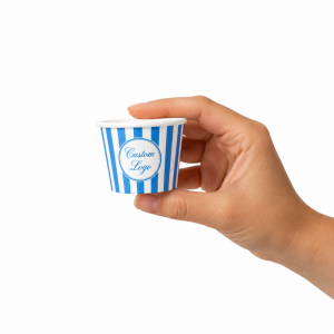 Hand holding a small blue striped custom logo paper coffee cup, showing the compact size for espresso or sample use.