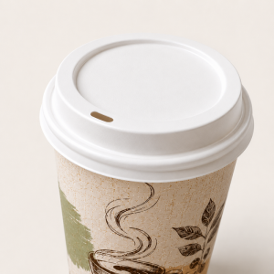 Vista superior aproximada de um copo de café descartável texturizado em papel kraft com tampa branca, estampa de desenho de café feito à mão, fundo creme liso.