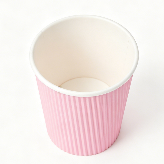Overhead shot single pink vertical ripple wall paper coffee cup, pure white seamless background, 8K close-up top view display inner lining and corrugated texture, blank custom printable disposable insulated espresso paper cup for bulk wholesale